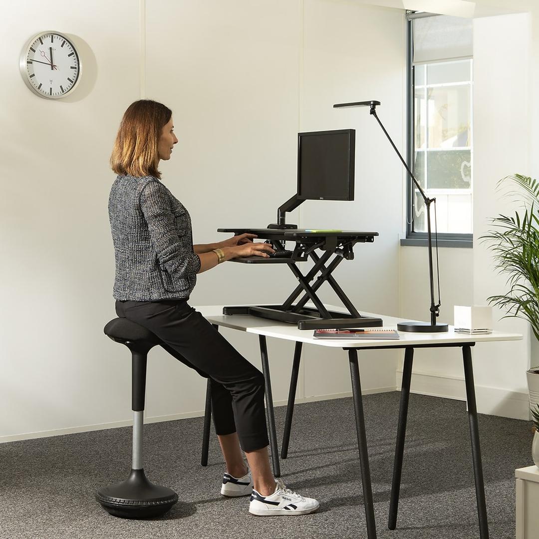 Tabouret assis-debout MOOVE noir UNILUX - Tabouret assis-debout UNILUX MOOVE noir, en situation à un bureau assis-debout
