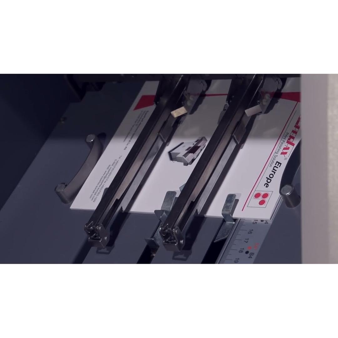 Plieuse-agrafeuse de livrets à dos carré SF-500EU SRA3 SUPERFAX - Les deux têtes d'agrafage de la plieuse-agrafeuse Superfax SF-500EU au-dessus d'une feuille