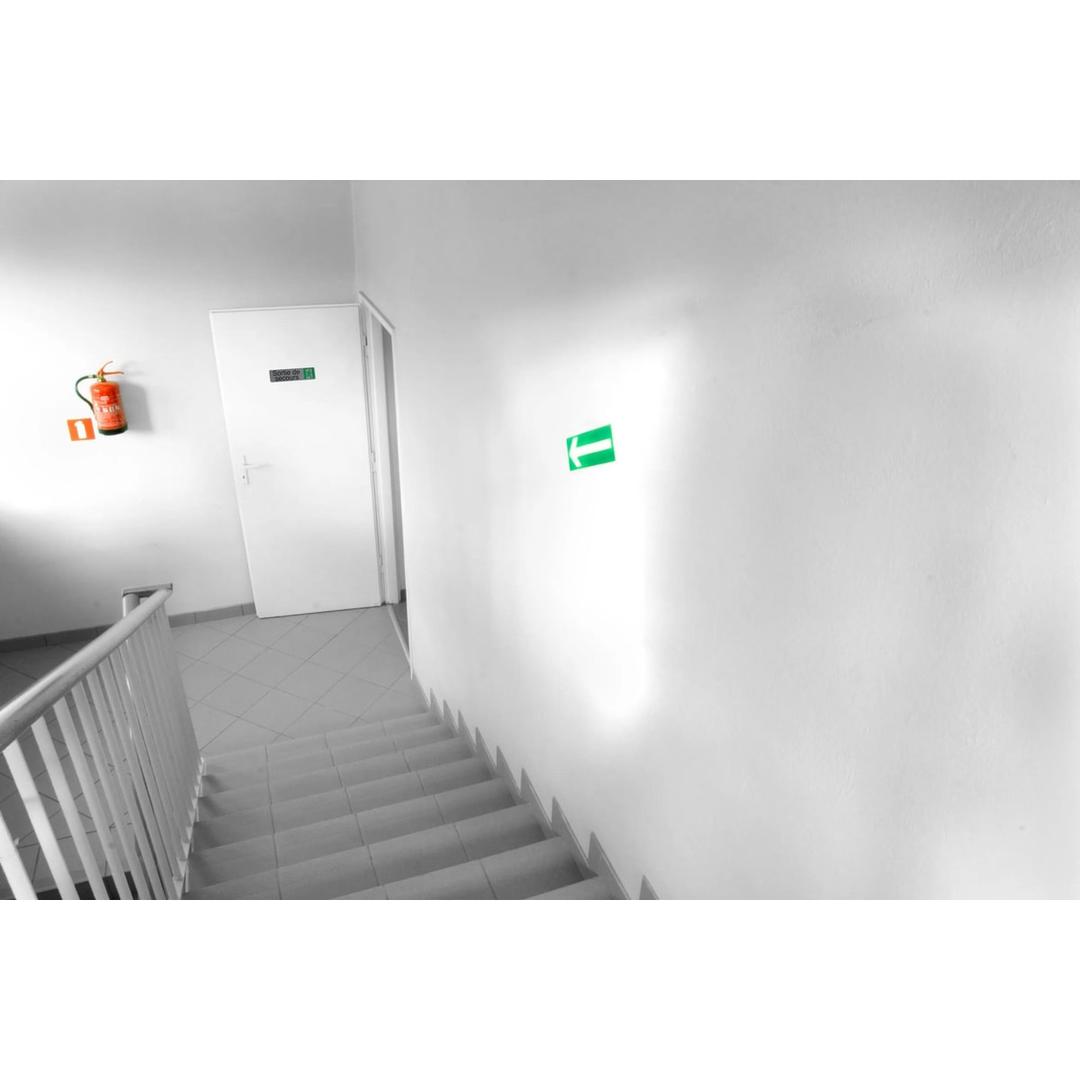 Plaque Sortie de secours EXACOMPTA collée au-dessus d'une porte