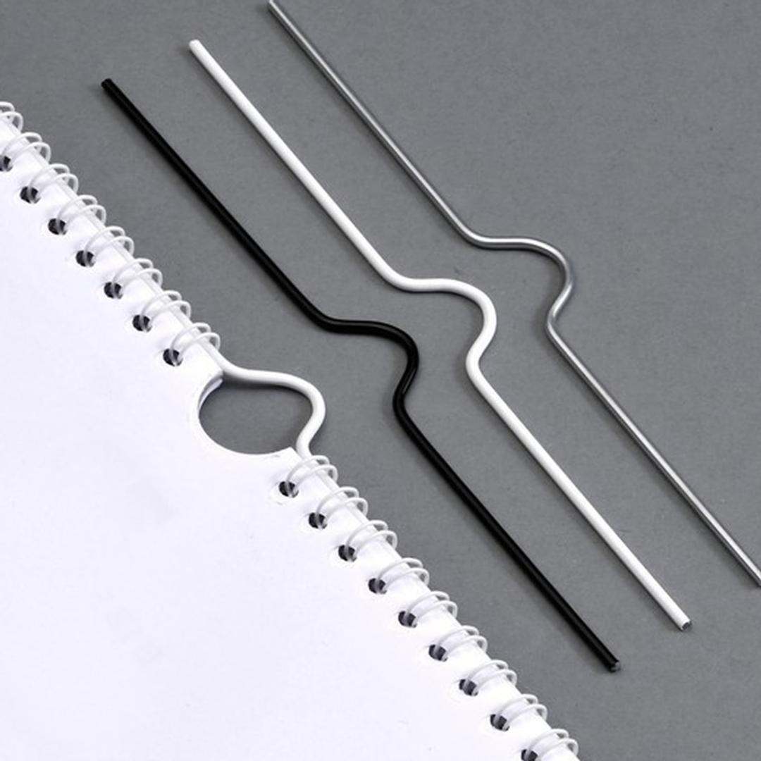 Crochets pour calendrier, reliure métallique Crochets de calendrier 100 mm, blancs WYNSTOR - Crochets de calendrier noir, blanc et argent, l'un passé dans l'encoche demi-lune d'un calendrier relié en anneaux métalliques