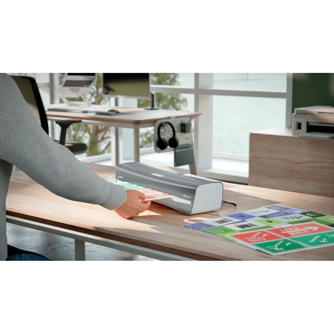 La plastifieuse à pochettes Leitz iLAM Office A3 posée sur un bureau, un document engagé dans la fente