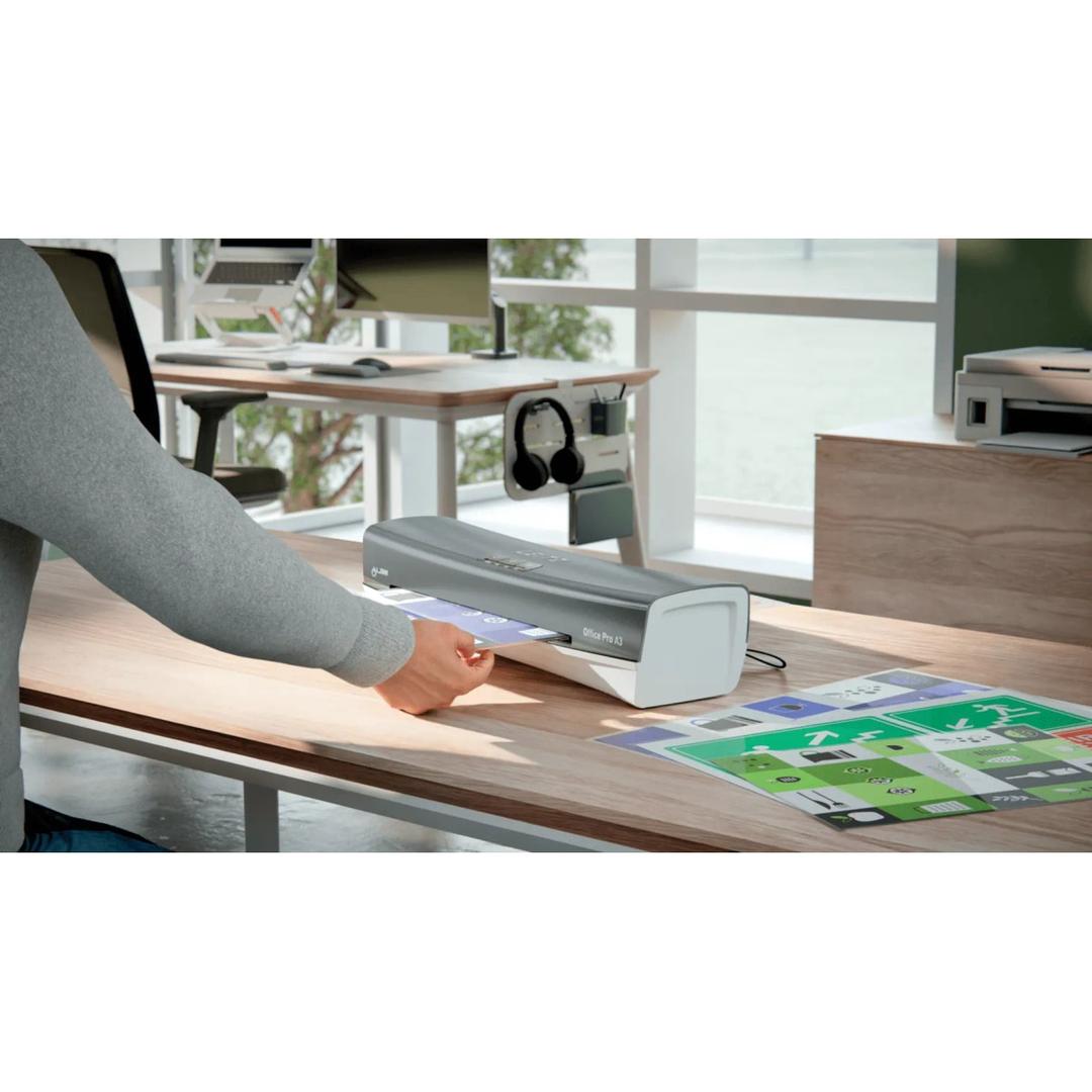 La plastifieuse à pochettes Leitz iLAM Office Pro A3 posée sur un bureau, un document engagé dans la fente