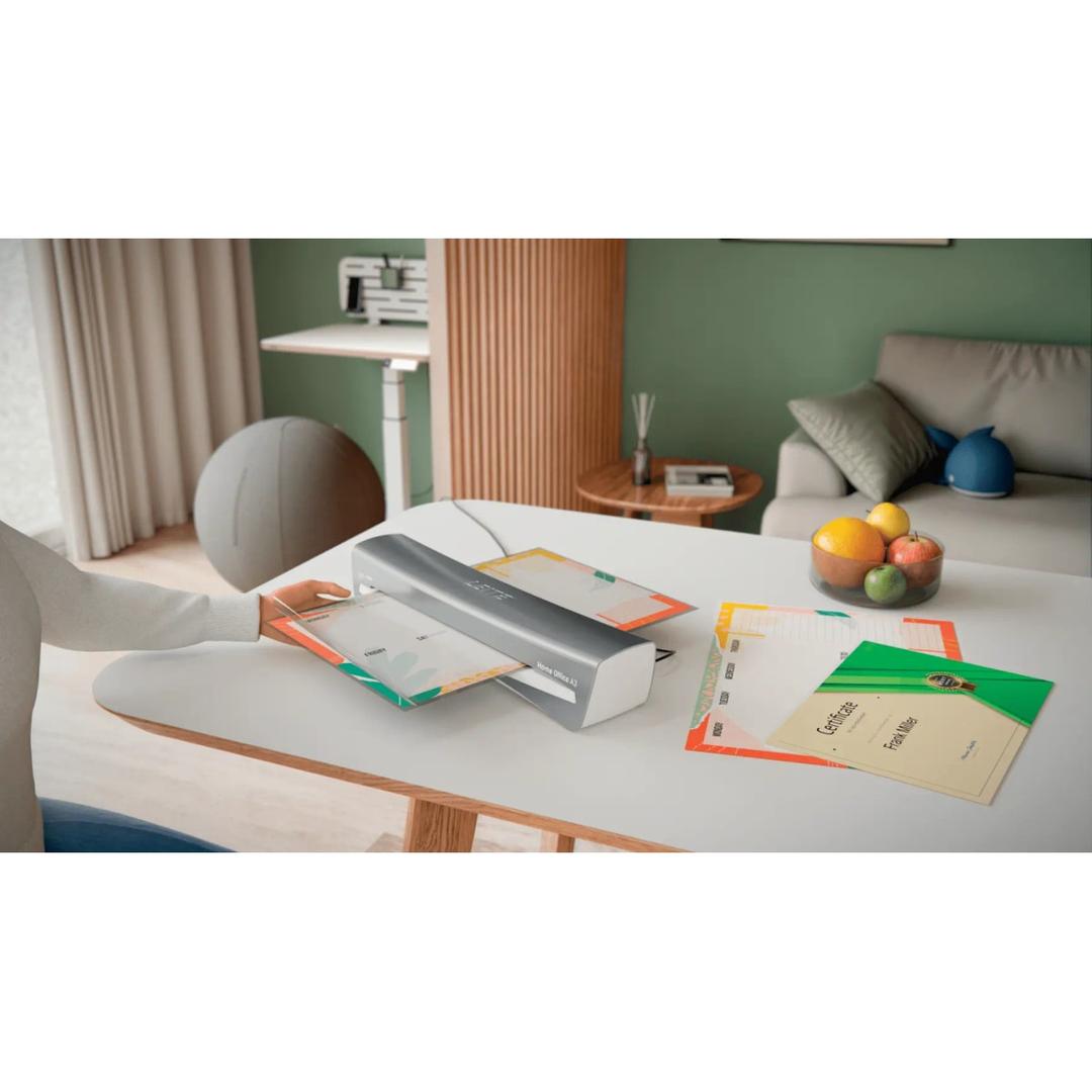 La plastifieuse à pochettes Leitz iLAM Home Office A3 posée sur un bureau, un document engagé dans la fente