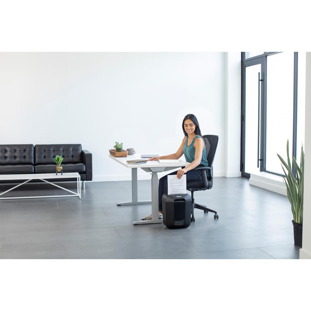 Aménagement d'un espace de travail à domicile avec un destructeur de documents de papier Fellowes Powershred LX45compacte sous le bureau.