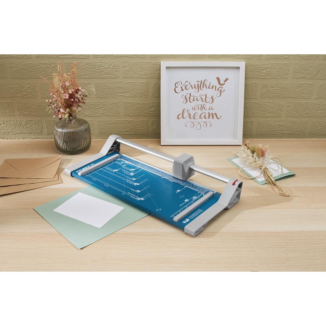 Rogneuse A4 à lame rotative DAHLE 507 posée sur une table avec des papiers à découper