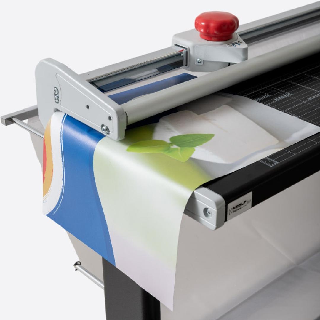 Coupeuse de plans manuelle A0+, jusqu'à 1,2 mm Manual Trim Plus 200 NEOLT - Bâche imprimée engagée sous la tête de coupe de la coupeuse de plans NEOLT Manual Trim Plus 200