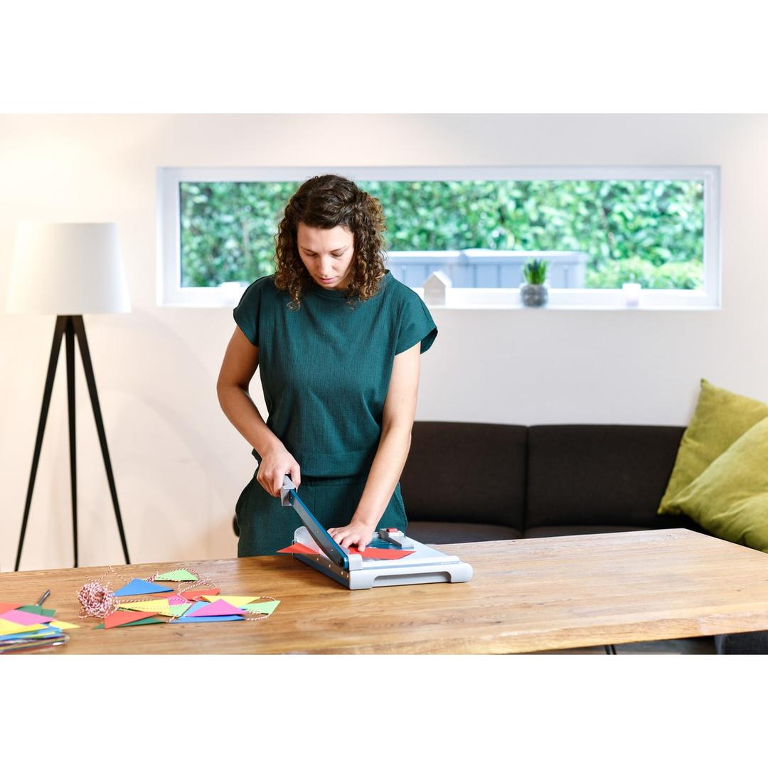 Cisaille papier A4 DAHLE 533 en situation : découpe de papier de couleur sur une table