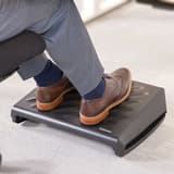 Repose-pieds réglable, 3 hauteurs et bascule Breyta FELLOWES - Pieds posés sur le repose-pieds Fellowes Breyta noir sous un bureau