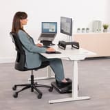 Repose-pieds réglable, 3 hauteurs et bascule Breyta FELLOWES - Repose-pieds Fellowes Breyta noir sous le bureau d'une utilisatrice assise