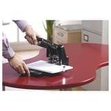 Perforateur Rexel HD2300 en usage sur un bureau, poignée abaissée sur une liasse.