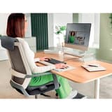 Sur batterie, assise et dossier, gris Couvre-siège chauffant iComfi LEITZ - Utilisatrice assise sur une chaise équipée du couvre-siège chauffant LEITZ iComfi