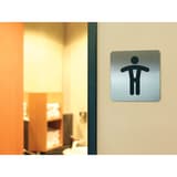 Inox brossé, carrée 150 x 150 mm Plaque WC hommes 4954 DURABLE - Plaque WC hommes DURABLE 4954 posée sur le mur de sanitaires