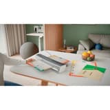 La plastifieuse à pochettes Leitz iLAM Home Office A3 posée sur un bureau, un document engagé dans la fente
