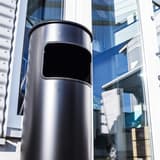 Cendrier-poubelle à couvercle étouffoir, 17 litres SAFE noir DURABLE - Cendrier-poubelle à couvercle étouffoir DURABLE SAFE noir, en situation à l'entrée d'un bâtiment