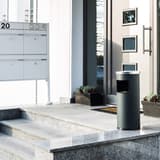 Cendrier-poubelle à couvercle étouffoir, 17 litres SAFE anthracite DURABLE - Cendrier-poubelle à couvercle étouffoir DURABLE SAFE anthracite, en situation à l'entrée d'un immeuble