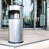 Cendrier-poubelle avec sable, 17 litres rond argent métallisé DURABLE - Cendrier-poubelle avec sable DURABLE rond argent métallisé, en situation à l'entrée d'un bâtiment