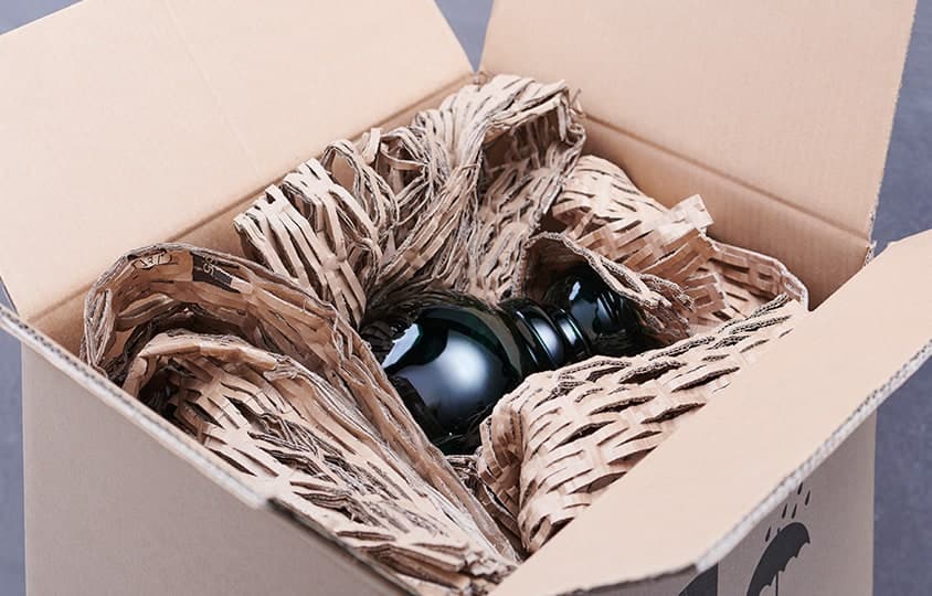 Vase calé dans un carton avec du calage en carton matelassé