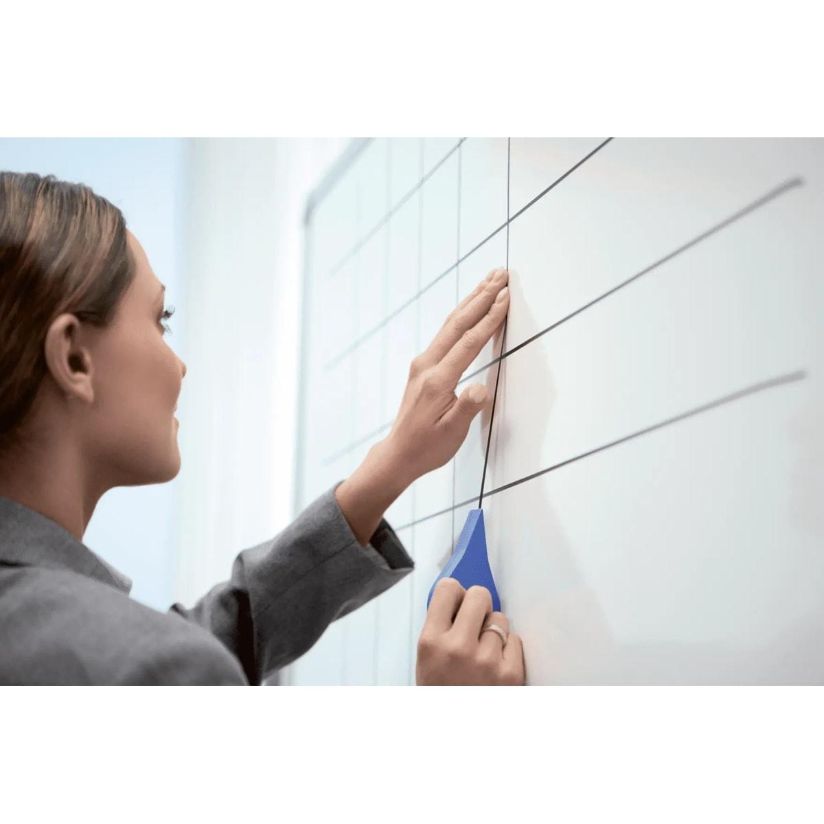 Pose du ruban autocollant nobo sur un tableau blanc